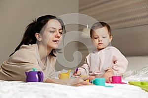 happy mother and cute little child daughter playing tea party