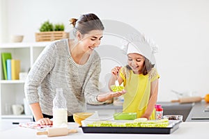 Happy mother and daughter baking cupcakes at home