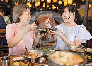 Happy mother and daughter celebrating mothers day at restaurant