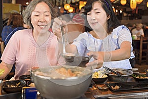 Happy mother and daughter celebrating mothers day at restaurant