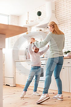 Happy mother and daughter feeling amazing dancing together