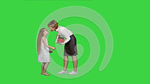 Happy mother and daughter giving and receiving gift box on a Green Screen, Chroma Key