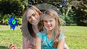 Happy mother and daughter holding pinwheel