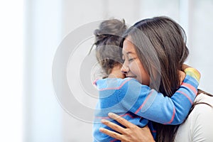 Happy mother and daughter hugging at home
