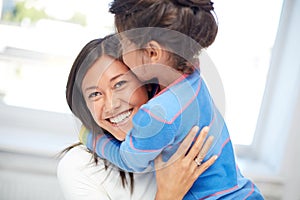 Happy mother and daughter hugging at home