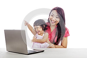 Happy mother and daughter with laptop