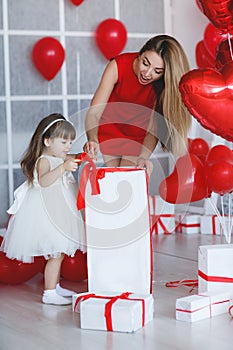 Happy mother and daughter parses gifts on Valentine`s Day