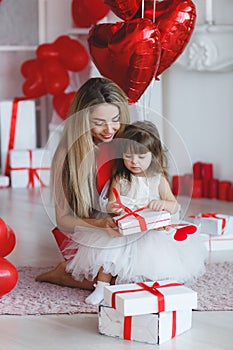 Happy mother and daughter parses gifts on Valentine`s Day