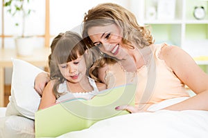 Happy mother and daughter reading a book together