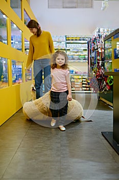 Happy mother and daughter shopping together at pet shop on weekend