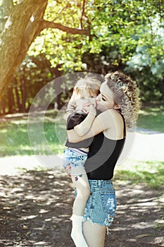 Happy mother with daughter similar look tender kiss