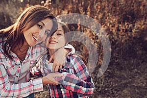 Happy mother and daughter on the walk on summer field. Family spending vacation outdoor