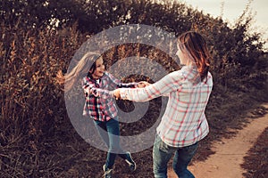 Happy mother and daughter on the walk on summer field. Family spending vacation outdoor