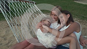 Happy mother with daughters rocking in hammock slow motion stock footage video stock footage video