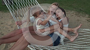 Happy mother with daughters rocking in hammock slow motion stock footage video stock footage video