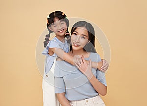 happy mother day. Adorable sweet young asian mother with cute little daughter hugging isolated on color background