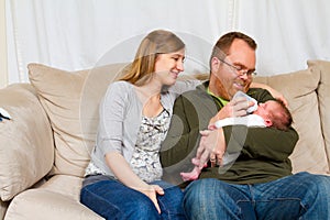 Happy Mother and Father Holding Newborn