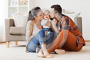 Happy mother and father kissing baby at home