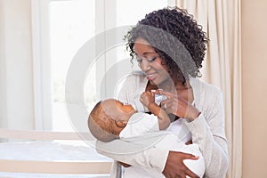 Happy mother feeding her baby boy his bottle