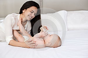 happy mother feeding her newborn baby on the bed