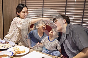 Happy mother feeds her family in restaurant