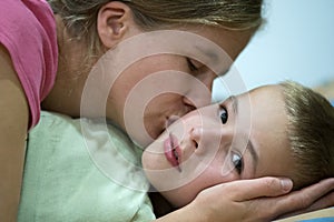 Happy mother gives her son a kiss before sleep and wish good night and beautiful dreams