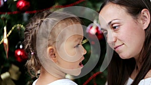 Happy mother having fun with her kids in christmas time next to christmas tree