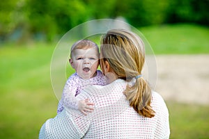 Happy mother having fun with newborn baby daughter, family portrait togehter. Mum with baby girl outdoors, love. New