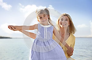 Happy mother and her child on beach. Spending time in nature