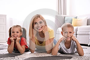Happy mother with her children on floor at home