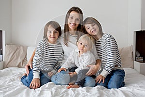 Happy mother and her children lying on bed