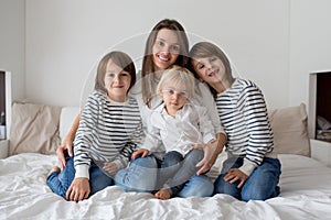 Happy mother and her children lying on bed