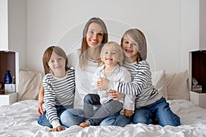 Happy mother and her children lying on bed