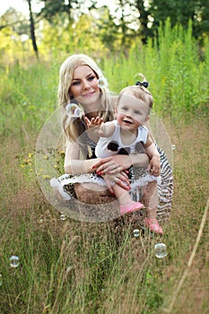 Happy mother and her daughter on the nature resting