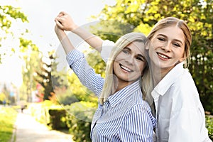 Happy mother with her daughter spending time together in park on day