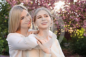 Happy mother with her daughter spending time together in park on sunny day