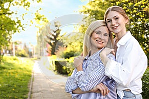 Happy mother with her daughter spending time together in park on sunny day