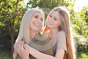 Happy mother with her daughter spending time together in park on sunny day