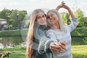 Happy mother with her daughter spending time together in park on sunny day