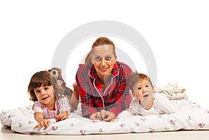 Happy mother and her kids in bed