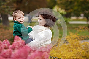 Happy mother and her little boy. Child playing with mother in the park. Mother and son embracing