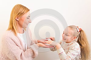 Happy mother and her little daughter having fun playing together
