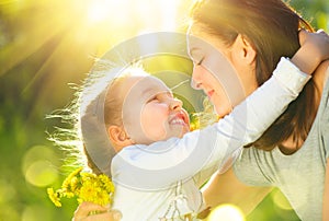 Happy mother and her little daughter outdoor. Mom and daughter enjoying nature together in green park