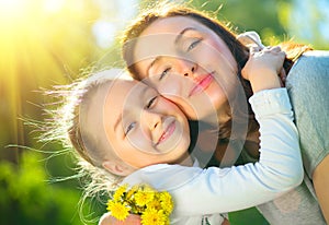 Happy mother and her little daughter outdoor. Mom and daughter enjoying nature together in green park