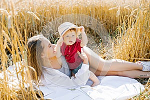 A happy mother and her little son are lying on a blanket at a picnic. Family walk in the field