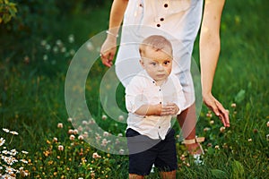 Happy mother with her son spending free time on the field at sunny day time of summer