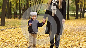 Happy mother and her son walking in autumn Park.