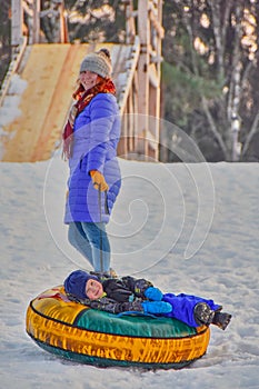 Happy mother and her son on a winter sleigh ride