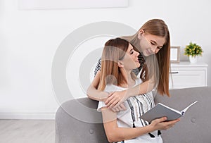 Happy mother and her teenage daughter with book