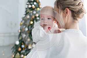 Happy mother with her young son on Christmas Eve near the Christmas tree